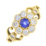 A sapphire and diamond floral cluster ring. The circular-shape sapphire, with brilliant-cut