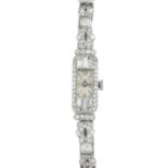 A mid 20th century platinum and 9ct gold diamond cocktail watch. The rectangular-shape dial, with