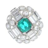 A mid 20th century platinum Colombian emerald and diamond dress ring. The rectangular-shape emerald,