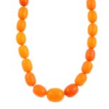 An amber necklace and earrings. The necklace designed as a graduated series of oval-shape amber