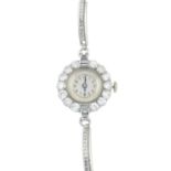 A lady's mid 20th century diamond cocktail watch. The circular dial, with Arabic numerals, to the