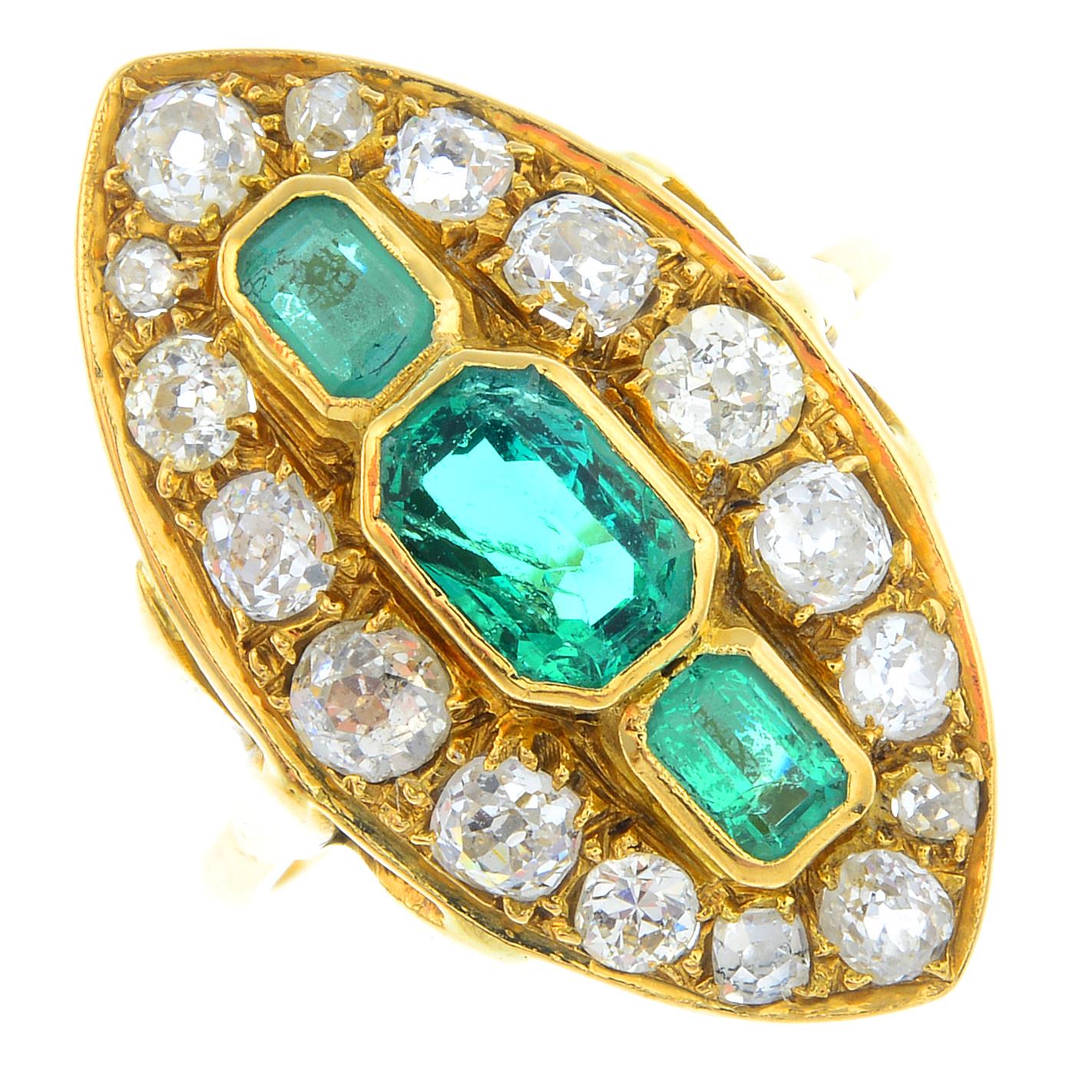 An emerald and diamond cluster ring. Of marquise-shape outline, the graduated rectangular-shape