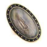 A Georgian gold and enamel memorial ring. The woven hair oval glazed panel, with gold monogram and