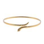 A 9ct gold garnet snake bangle and a gate bracelet. The bangle designed as a 9ct gold crossover