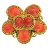 An early 20th century coral brooch. Designed as a coral cameo cluster, each oval coral panel