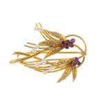 A 9ct gold ruby and seed pearl brooch. Designed as a floral spray, with circular-shape ruby