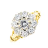 An 18ct gold diamond cluster ring. The brilliant-cut diamond, with similarly-cut diamond surround,