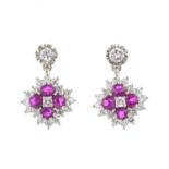 A pair of 18ct gold ruby and diamond earrings. Each designed as a circular-shape ruby and