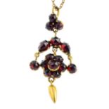 A late Victorian garnet pendant. Designed as a vari-shape garnet floral cluster and fringe,