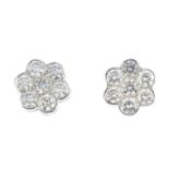 A pair of diamond earrings. Each designed as a brilliant-cut diamond floral cluster. Estimated total