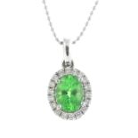 A tsavorite garnet and diamond cluster pendant. The oval-shape tsavorite garnet, within a