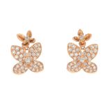 A pair of diamond floral earrings. Each designed as a pave-set diamond flower, with brilliant-cut