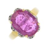 An 18ct gold glass-filled ruby and diamond cluster ring. The oval-shape glass-filled ruby, with