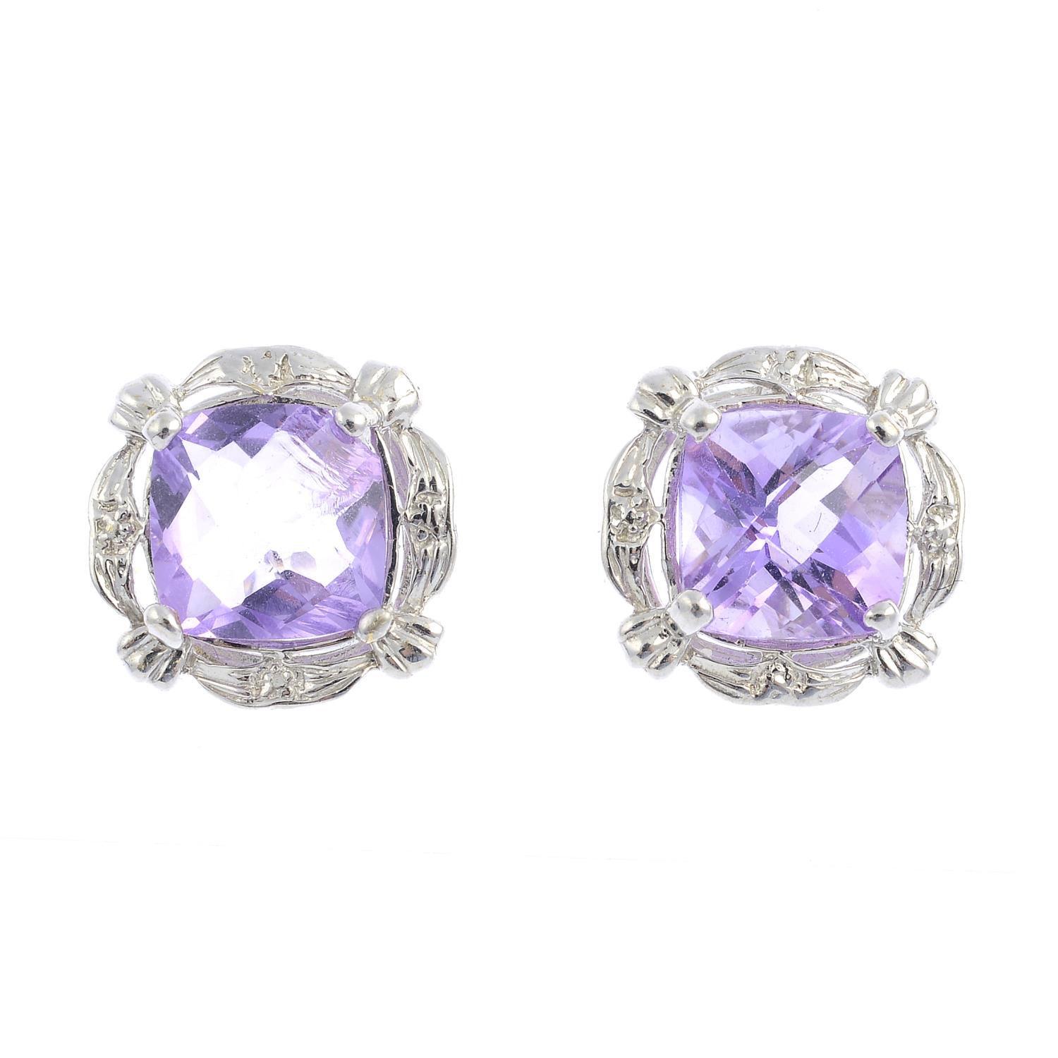 A pair of amethyst earrings. Each designed as a cushion-shape amethyst, within a grooved openwork