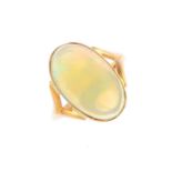 An opal single-stone ring. The oval opal cabochon collet, with chevron shoulders. Estimated