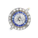 A diamond and sapphire cluster ring. The circular-cut diamond, within a calibre-cut sapphire and