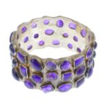 A silver amethyst bangle. The scattered vari-shape amethyst collets, atop a textured bangle.