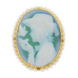 An agate and seed pearl brooch. The oval agate cameo carved to depict a girl playing with birds,