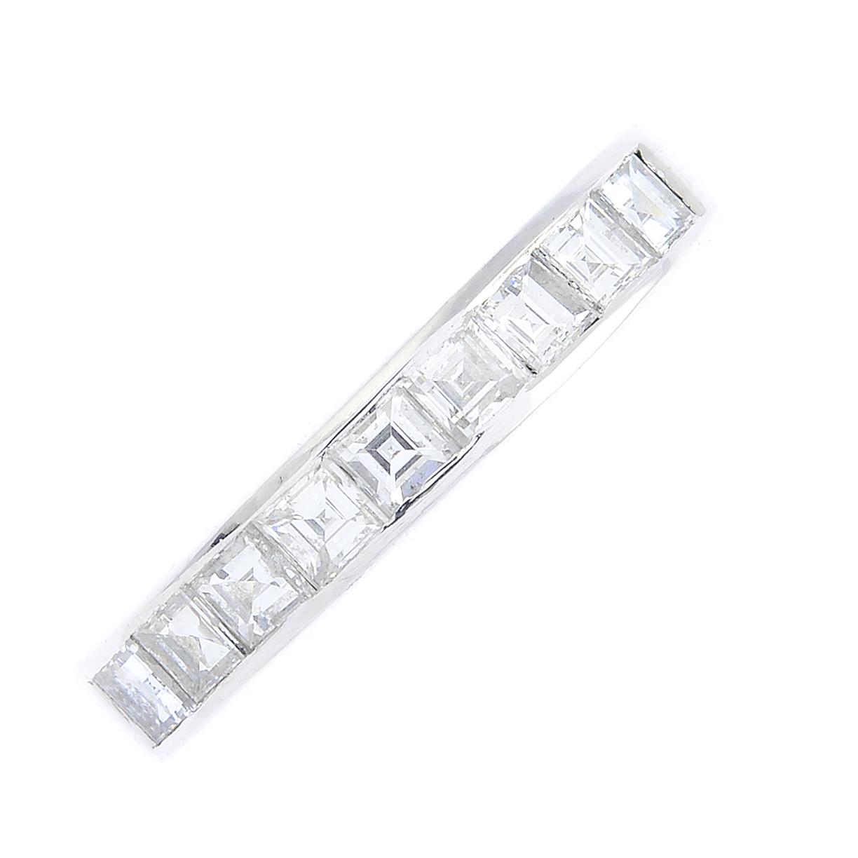 An 18ct gold diamond half eternity ring. Designed as a square-shape diamond line, within a channel