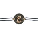 A diamond bracelet. The brilliant-cut diamond Arabic script, atop the circular textured panel,