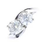 An 18ct gold diamond two-stone ring. Designed as a circular-cut diamond graduated line, with