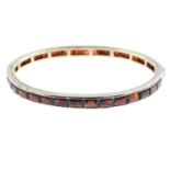 Two garnet hinged bangles. Each designed as a rectangular-shape garnet line, within a channel