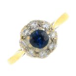 An 18ct gold sapphire and diamond cluster ring. The circular-shape sapphire, with single-cut diamond