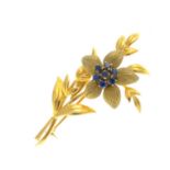 An 18ct gold sapphire floral brooch. The circular-shape sapphire cluster and textured petal flower