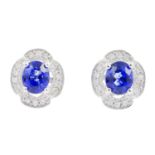 A pair of sapphire and diamond cluster earrings. Each designed as an oval-shape sapphire, within a