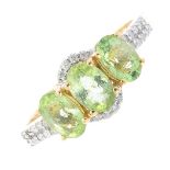 An 18ct gold tourmaline and diamond dress ring. The oval-shape green tourmaline trio, with