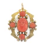 A late Victorian coral pendant. Of openwork design, the carved coral figure, with coral quatrefoil