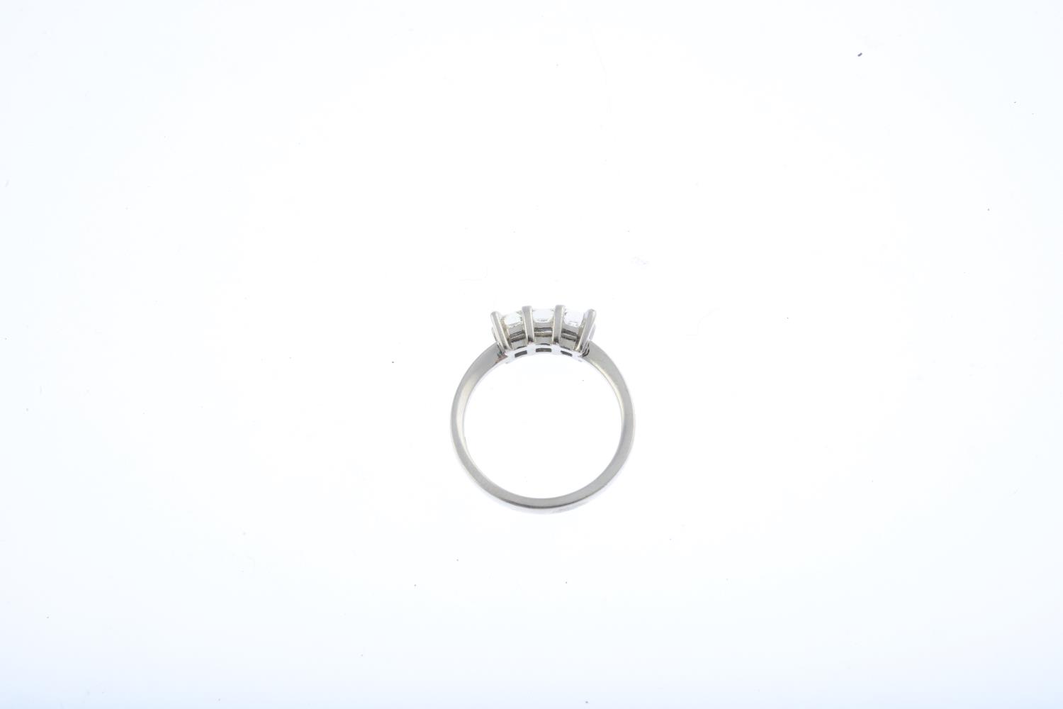 An 18ct gold diamond three-stone ring. Designed as a square-shape diamond line, with plain band. - Image 2 of 3