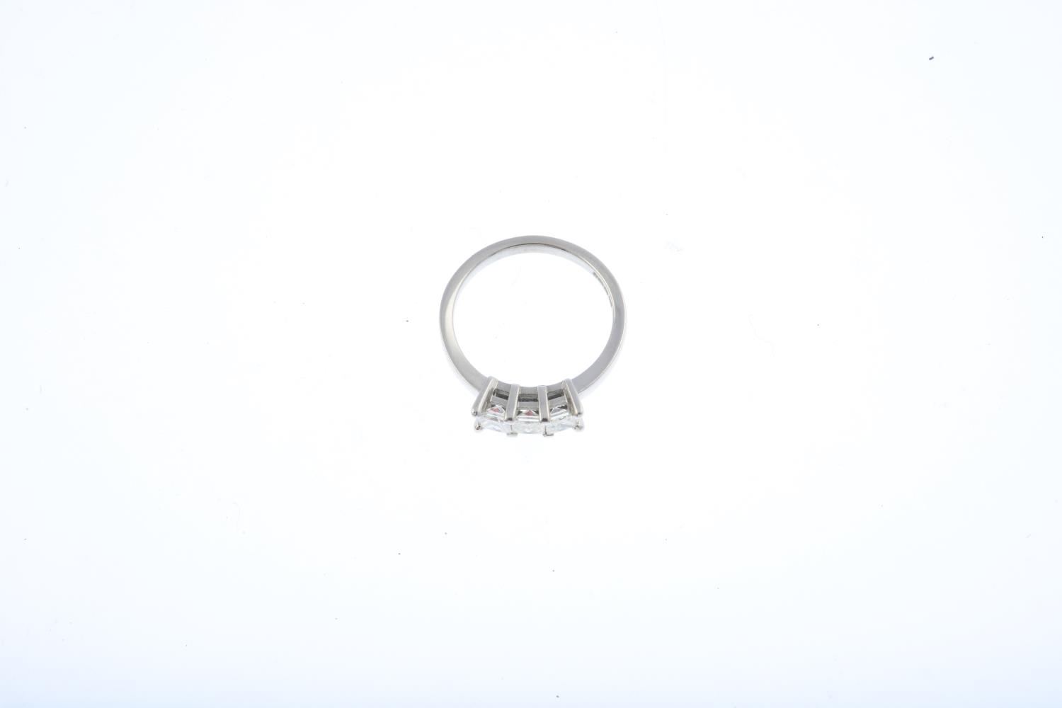 An 18ct gold diamond three-stone ring. Designed as a square-shape diamond line, with plain band. - Image 3 of 3