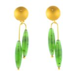 A pair of jade earrings. Each designed as a pair of asymmetric nephrite jade cylinder drops,