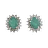 A pair of emerald and diamond cluster earrings.