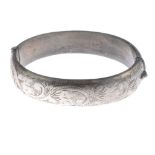 A selection of silver and white metal bangles. To include a silver hinge bangle with engraved detail