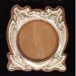 John Atkin and Son- An Arts and Crafts hallmarked silver shield shaped easel photograph frame,