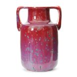 Ruskin Pottery - A high fired twin handled barrel vase decorated in a red and lavender glaze with