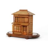 An early 20th Century Japanese straw work model of a pagoda type house with figures in an