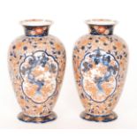 A pair of late 19th Century Japanese Imari footed vases each decorated with cartouche panels