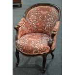 A Victorian carved mahogany tub shaped elbow chair, upholstered in printed pink fabric,