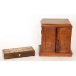 A Victorian walnut smokers cabinet fitted with three drawers enclosed by a pair of inlaid doors and