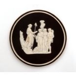 A late 18th Century basalt medallion with relief applied scene in white depicting Peace,