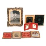 A collection of five Victorian ambrotype photographs and a later photograph in a red leather case