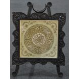 A late Victorian dark oak easel firescreen in the Aesthetic taste,