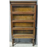 A 1920s oak four section glazed bookcase on turned legs,