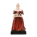 A 1920s counter top advertising figure for Jacobian Glassware modelled as a lady in a red dress