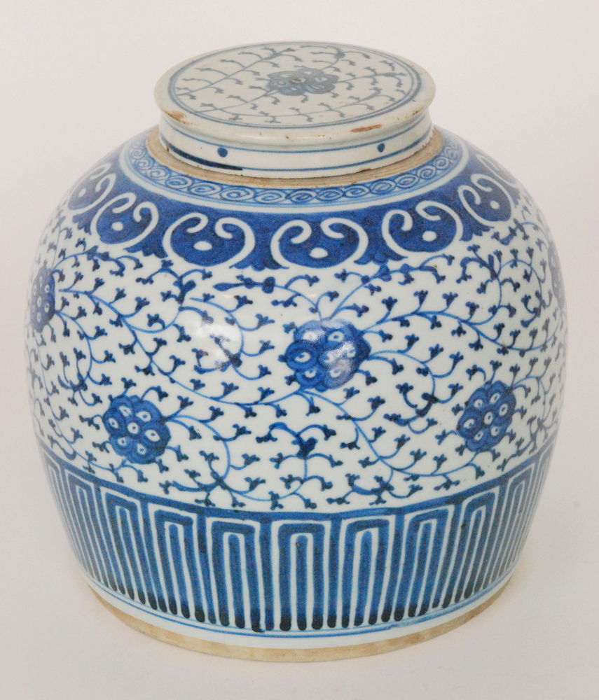 A Chinese blue and white ginger jar and cover decorated with flowers and foliage against a karakusa