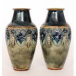 A pair of early 20th Century Royal Doulton stoneware vases each decorated with tubelined flowers