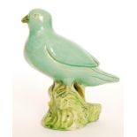 A Chinese clay model of a bird perched on a branch, the whole glazed in green, unmarked,